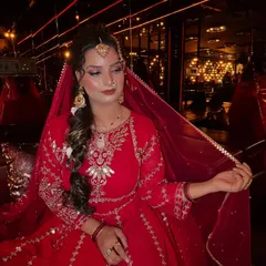 This image captures the bride's elegance, with her holding the sheer red dupatta. The focus is on the intricate embroidery of her outfit and the way the makeup complements the traditional aesthetic.