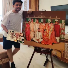 Vivek proudly standing with a large, detailed family portrait. This painting was commissioned for a special occasion, bringing together ten family members into one harmonious composition.