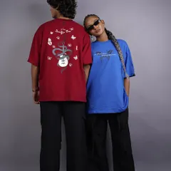A relaxed shot of two models showcasing the front and back designs of graphic tees. The female model's pose adds a touch of connection and ease, creating a relatable image for a streetwear brand's lookbook.