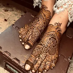A crossed-feet pose showing the beautiful flow of the design. This is a classic choice for bridal feet mehendi.