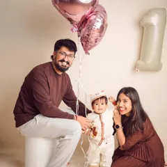 A happy family celebrating their son's first birthday. Using balloons is a simple and festive way to add a celebratory touch to milestone photos.