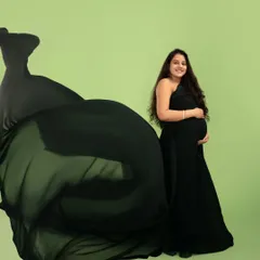 The classic black gown, elevated with a dramatic fabric toss. This technique adds movement and elegance, creating a timeless yet striking image that celebrates your changing form.