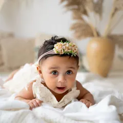 This is a classic shot from a 6-month session. The tummy time pose is perfect for showing off how strong they're getting, and her curious expression is just priceless.