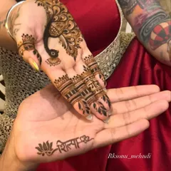 A beautiful moment between a couple, each getting a personalized mehndi design. She has his name on her hand, and he has hers, a simple yet powerful symbol of their bond.