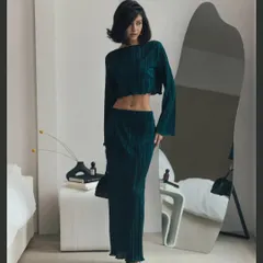This pleated two-piece set in a deep teal is perfect for a sophisticated yet comfortable look. The long-sleeve crop top and matching maxi skirt create an elegant, elongated silhouette.