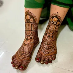 A beautiful and dense foot design that matches the style of full bridal hand mehndi. It features lotus flowers and intricate jaali (net) patterns.