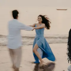 A joyful, motion-filled photo of the couple dancing on the sand at sunset, capturing pure happiness.