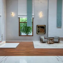 We design spaces for modern life and spiritual tranquility. This double-height room combines a serene pooja area with a minimalist lounge, using wood flooring to define the sacred space and elegant drapery to soften the grand scale.