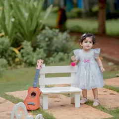 A tiny musician and her guitar. This setup with a miniature bench and instrument is perfect for a whimsical and sweet portrait of a baby girl. The natural garden setting adds to the soft, dreamy feel.