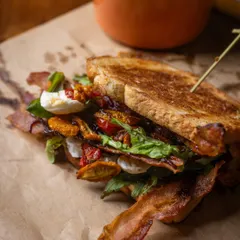 This isn't your everyday BLT. I've layered crispy bacon, fresh arugula, and sweet onion jam with a creamy aioli, all tucked inside soft milk bread. It’s a sandwich that’s both comforting and a little adventurous.