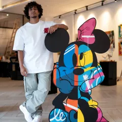Standing with my finished Minnie Mouse artwork. This piece is huge, standing 55 inches tall, and uses vibrant spray-painted colors on layered MDF to bring her to life.