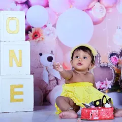 Getting a little taste of the frosting. Cake smash sessions are all about capturing these small, curious moments that show off your baby's personality.