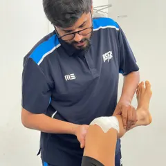 One of our physiotherapists applies McConnell taping to a client's knee, a technique used to correct patellar tracking issues and reduce pain during movement.
