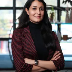 A corporate portrait with a striped blazer, adding a touch of personality. The arms-crossed pose conveys professionalism and authority.