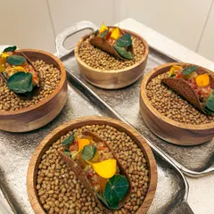 Canapé-sized mushroom tacos, filled with fermented garlic aioli, green papaya som tam, and a truffle egg yolk gel.