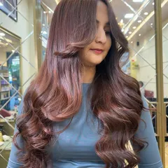 A beautiful profile shot of the Mocha Mousse color. The face framing layers and soft waves create a stunning, glamorous look.