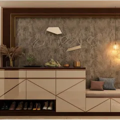 A luxurious foyer design with a glossy, geometric-patterned shoe cabinet that includes a built-in bench. The textured accent wall and warm lighting create a sophisticated and welcoming entrance.
