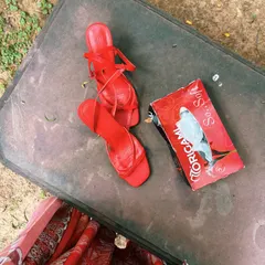 The not-so-glamorous side of a shoot. Red heels and a box of tissues on a dusty surface, a real moment between takes.