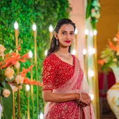 Posing by the floral decor, this client's makeup and hair look fresh and beautiful. The bright red lip stands out, and her simple hairstyle keeps the focus on her and her lovely attire.