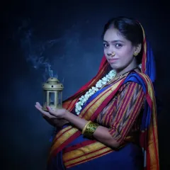 A moody and atmospheric portrait. The traditional Khan saree, the nath, and the gentle smoke from the lantern create a vintage, soulful look that is full of meaning.