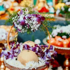 This platter is designed for auspicious offerings, featuring coconuts decorated with beautiful purple orchids and white chrysanthemums. It's perfect for poojas and welcome arrangements.