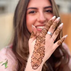 A happy client showing off her simple and elegant Arabic belt mehendi.