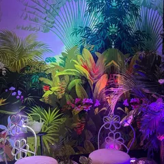 Another view of the jungle photo booth, this time with symmetrical lighting that creates a captivating visual effect on the tropical wallpaper. The design is both artistic and interactive.