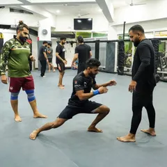 A moment of instruction and stretching during a class. Our coaches are always engaged, helping students improve their mobility and technique.