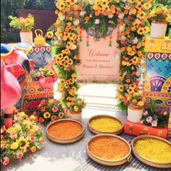 We love bringing vibrant energy to pre-wedding functions. This Haldi ceremony entrance features a playful theme with bright sunflowers, quirky flamingo props, and colorful hand-painted trunks.