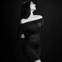 A classic black and white portrait. The off-the-shoulder dress and the elegant pose create a timeless and sophisticated look, essential for any model's book.