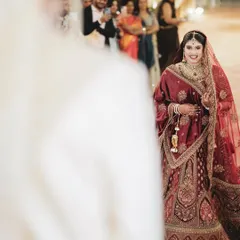 The first look. This over-the-shoulder shot captures the bride's radiant smile as she sees her groom for the first time at the ceremony.