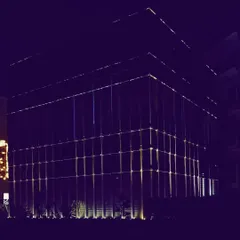 A wide-angle shot of the Zirakpur office project, showing how the illuminated facade establishes a strong presence. The design uses light to define the building's entire volume against the night sky.
