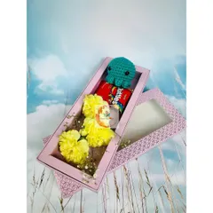 A cute and affordable gift box under ₹1000. This slim pink box holds fresh yellow carnations, Skittles, and a charming crocheted octopus.