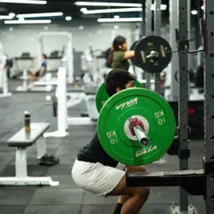 The squat is a cornerstone of strength. Here, a member demonstrates proper depth and form under load, building powerful legs and a strong core.