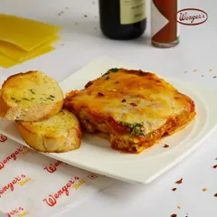When you need something more than just a snack, our Chicken Lasagna is here for you. This image shows a hearty portion of our baked lasagna, layered with rich sauce, tender chicken, and melted cheese, served with a side of garlic bread. It’s a complete, comforting meal from our deli counter.