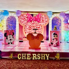 A creative and fun Minnie Mouse themed party for a second birthday. The centerpiece is a giant Minnie head silhouette filled with hundreds of pink balloons, creating a memorable photo opportunity.