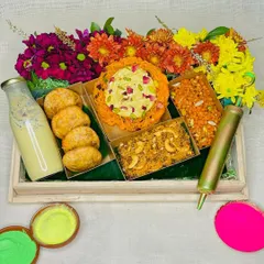 Our exclusive Holi gifting hamper, bursting with color and traditional flavors. It features Ghewar, Kachoris, and Thandai, beautifully arranged with fresh flowers.