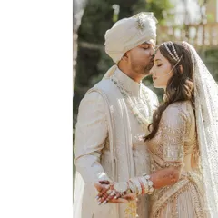 A tender moment between the bride and groom. This shot beautifully captures the intricate embroidery on the groom's sherwani and the delicate veil of the bride's lehenga, highlighting the craftsmanship of their wedding attire.