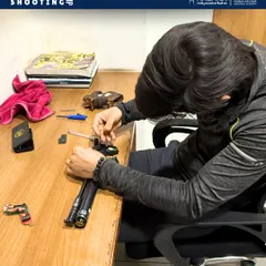 Our summer camps offer a deep dive into the science of shooting. Here, a young athlete is seen servicing his air pistol, learning about trigger velocity and weight adjustments under expert supervision.