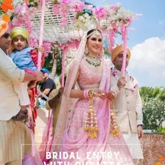 A beautiful bridal entry under a 'phoolon ki chaadar' made of a pink dupatta and decorated with flowers, held by her loved ones.
