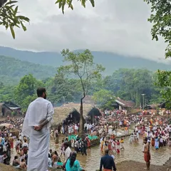 A wide shot of the Kottiyoor Mahadeva temple festival, showing the immense crowd of devotees gathered by the river. This image captures the scale and communal spirit of a major religious event.