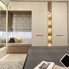 A perfect example of integrated design. This bedroom features a cozy bay window seat built right into the wardrobe unit, which also includes an open, lit display niche for personal treasures.