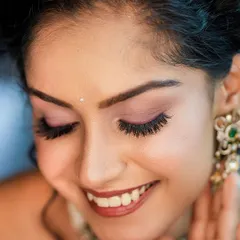 A joyful close-up focusing on the model's smile and flawless makeup, particularly the eyelashes. This shows our ability to capture beauty details.