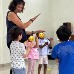 Naheed guides a group of children through hand signs, a key component of the Kodály method for teaching solfege and pitch relationships. Her direct interaction shows the personal attention given in our classes.