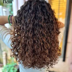 Adding some dimension to make them curls pop. This is a beautiful example of a curly balayage, where highlights are carefully painted to follow the curl pattern and add light.
