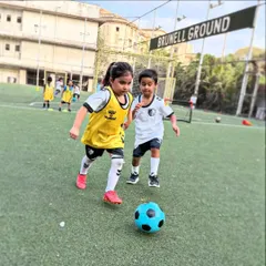 A boy and a girl challenge for the ball, showcasing the competitive but friendly spirit of our mixed-gender training games.