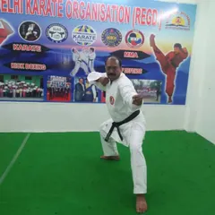 An instructor demonstrates a classic karate stance (kata) inside the dojo. Perfect form is the foundation of power, and our instructors lead by example in every class.