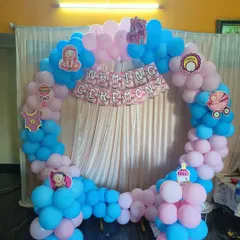 A cheerful and simple naming ceremony decoration with a pink and blue balloon ring and a "Naming Ceremony" banner.