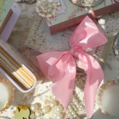 More details from the Bridgerton luncheon, featuring a pink satin bow, vintage books, and custom embellishments that add to the romantic and personalized feel of the event.