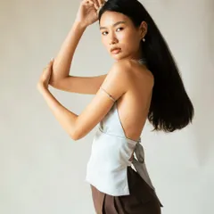 A three-quarter shot highlighting the backless top, demonstrating the model's ability to execute classic fashion poses.